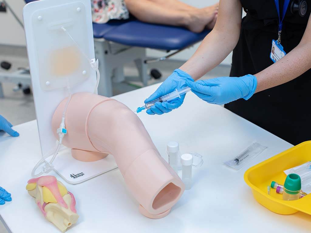 Close up of trainee doctor performing a simulated knee aspiration