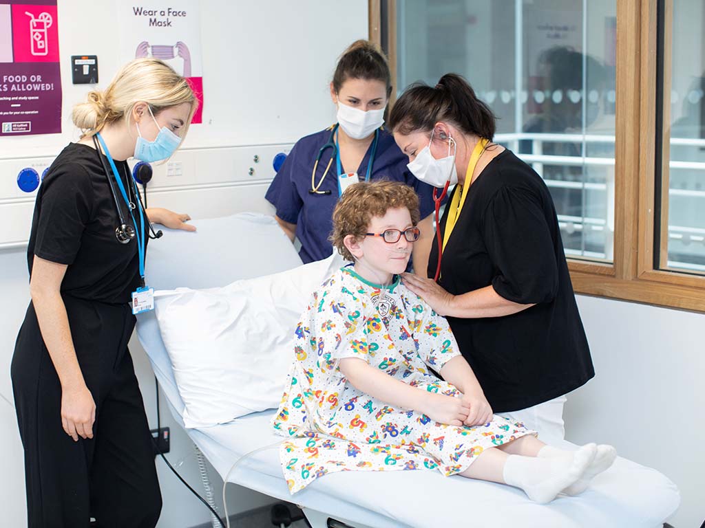 Paediatric consultant and trainees examine a little boy
